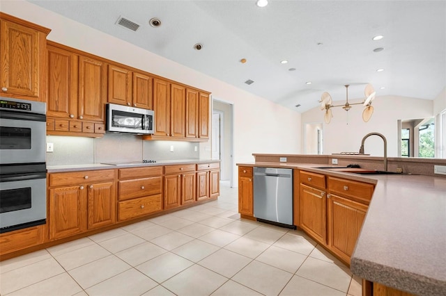 8312 Misty Lake Cir, Sarasota, FL 34241 - kitchen with appliances with stainless steel finishes, lofted ceiling, brown cabinets, light countertops, and recessed lighting