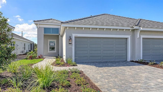 2321 Blue Mahoe Ln, Sarasota, FL 34240 - view of property featuring a tiled roof, stucco siding, and decorative driveway