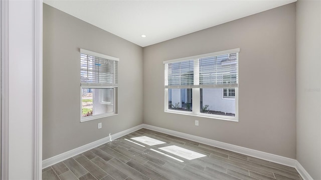 2321 Blue Mahoe Ln, Sarasota, FL 34240 - empty room with healthy amount of natural light, baseboards, wood finished floors, and recessed lighting