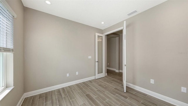 2321 Blue Mahoe Ln, Sarasota, FL 34240 - empty room featuring baseboards, wood finished floors, recessed lighting, and healthy amount of natural light