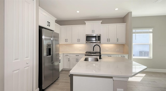 2321 Blue Mahoe Ln, Sarasota, FL 34240 - kitchen with appliances with stainless steel finishes, wood tiled floors, a sink, an island with sink, and recessed lighting