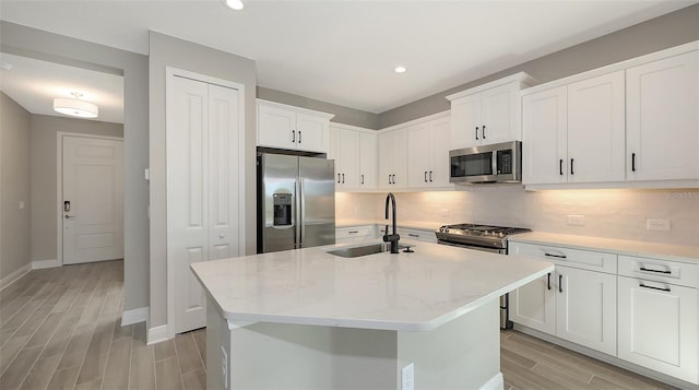 2321 Blue Mahoe Ln, Sarasota, FL 34240 - kitchen with stainless steel appliances, wood tiled floors, a sink, tasteful backsplash, and recessed lighting