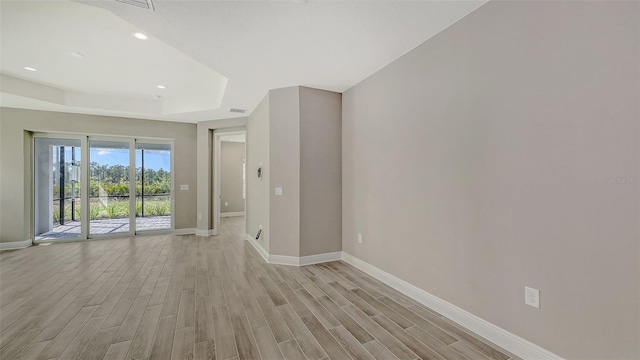 2321 Blue Mahoe Ln, Sarasota, FL 34240 - spare room featuring baseboards, a tray ceiling, light wood-style floors, and recessed lighting
