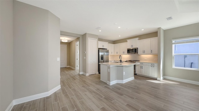 2321 Blue Mahoe Ln, Sarasota, FL 34240 - kitchen with stainless steel appliances, a sink, light wood finished floors, light countertops, and recessed lighting