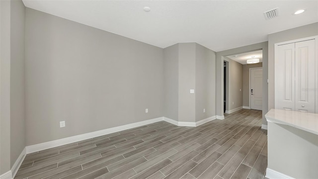 2321 Blue Mahoe Ln, Sarasota, FL 34240 - unfurnished room featuring baseboards, wood finished floors, and recessed lighting