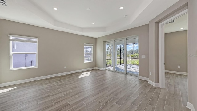 2321 Blue Mahoe Ln, Sarasota, FL 34240 - unfurnished room featuring a tray ceiling, light wood-type flooring, baseboards, and recessed lighting