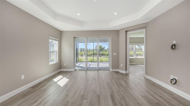 2321 Blue Mahoe Ln, Sarasota, FL 34240 - spare room with a raised ceiling, wood finished floors, baseboards, and recessed lighting