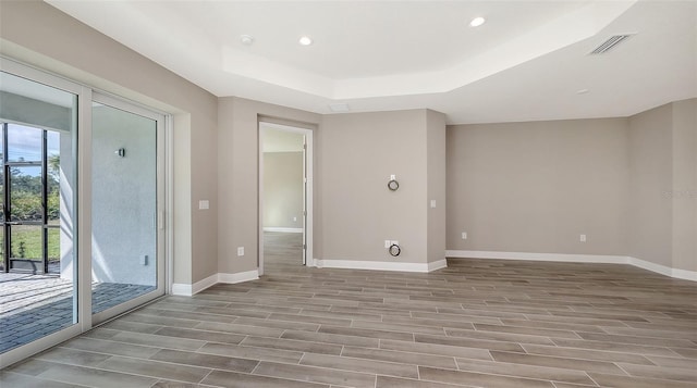 2321 Blue Mahoe Ln, Sarasota, FL 34240 - unfurnished room featuring a raised ceiling, wood finished floors, recessed lighting, and baseboards