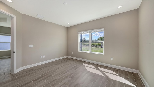 2321 Blue Mahoe Ln, Sarasota, FL 34240 - unfurnished room featuring baseboards, wood finished floors, and recessed lighting