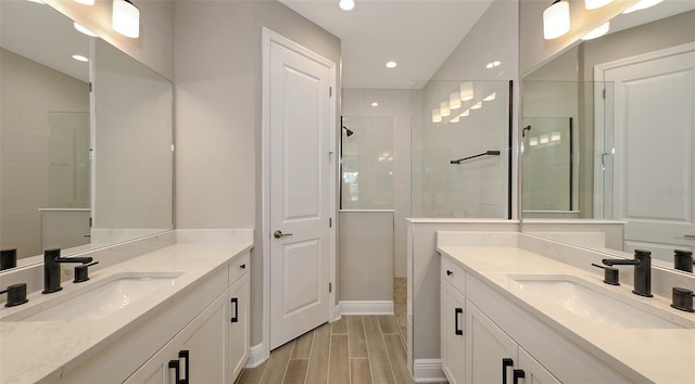 2321 Blue Mahoe Ln, Sarasota, FL 34240 - full bath with two vanities, walk in shower, wood finish floors, recessed lighting, and baseboards