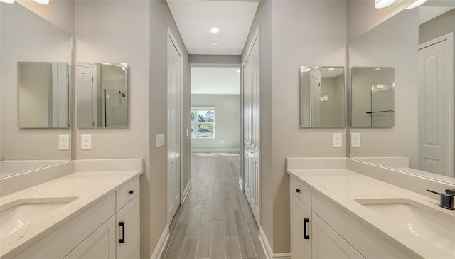 2321 Blue Mahoe Ln, Sarasota, FL 34240 - full bath featuring baseboards, two vanities, wood finished floors, and recessed lighting