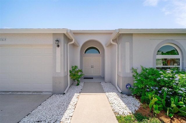 5410 Matthew Ct, Sarasota, FL 34231 - view of exterior entry featuring stucco siding and a garage