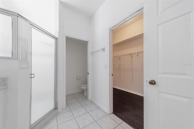 5410 Matthew Ct, Sarasota, FL 34231 - bathroom with a shower stall, a walk in closet, and tile patterned floors