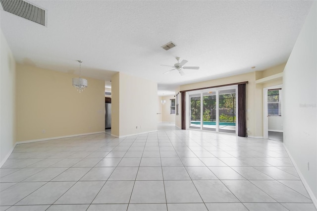 5410 Matthew Ct, Sarasota, FL 34231 - unfurnished room with light tile patterned flooring, ceiling fan, a textured ceiling, and a chandelier