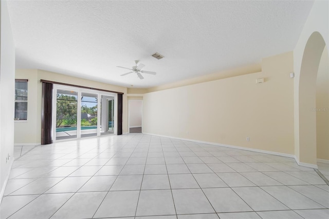 5410 Matthew Ct, Sarasota, FL 34231 - unfurnished room featuring ceiling fan, a textured ceiling, light tile patterned floors, and arched walkways