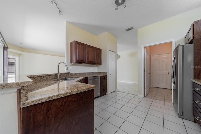 5410 Matthew Ct, Sarasota, FL 34231 - kitchen with appliances with stainless steel finishes, light tile patterned floors, light stone counters, and a peninsula