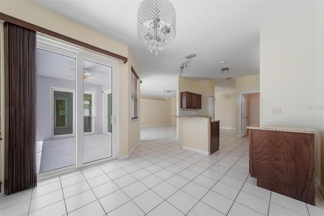 5410 Matthew Ct, Sarasota, FL 34231 - kitchen with ceiling fan, a chandelier, a peninsula, and light tile patterned floors
