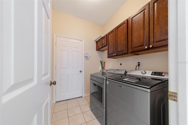 5410 Matthew Ct, Sarasota, FL 34231 - laundry area featuring washer and clothes dryer, cabinet space, and light tile patterned floors