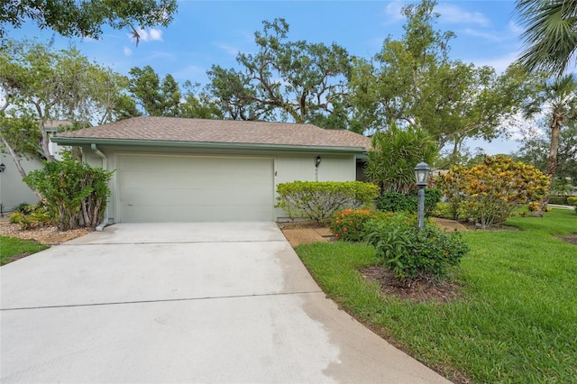 4637 Willow Wood Cir Unit 44, Sarasota, FL 34241 - view of side of property featuring an attached garage, concrete driveway, stucco siding, and a yard