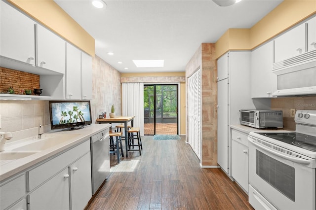 4637 Willow Wood Cir Unit 44, Sarasota, FL 34241 - kitchen with white appliances, dark wood-style floors, light countertops, white cabinets, and recessed lighting