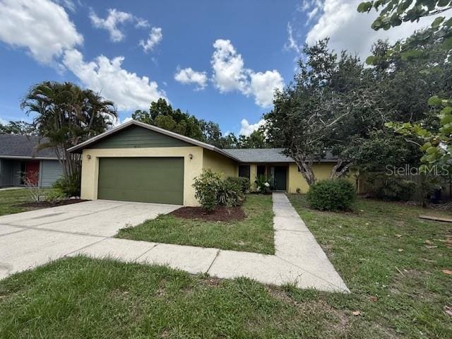 5032 81st Avenue Terrace E, Sarasota, FL 34243 - ranch-style house with a garage, concrete driveway, stucco siding, and a front yard