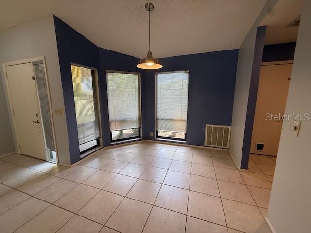 5032 81st Avenue Terrace E, Sarasota, FL 34243 - unfurnished dining area with light tile patterned floors and lofted ceiling