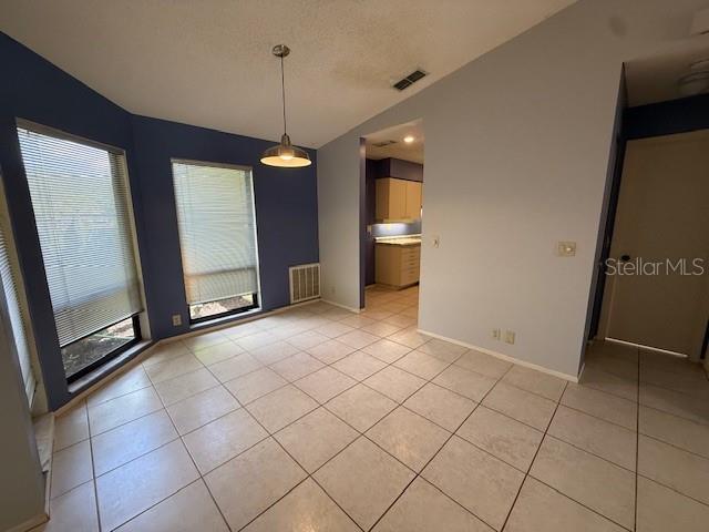 5032 81st Avenue Terrace E, Sarasota, FL 34243 - unfurnished dining area with lofted ceiling, plenty of natural light, and light tile patterned floors