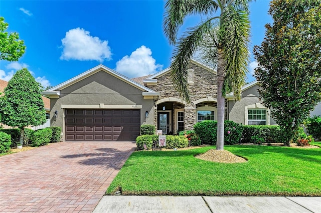 5307 65th Ter E, Ellenton, FL 34222 - view of front facade featuring stucco siding, a garage, stone siding, decorative driveway, and a front yard