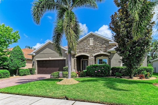 5307 65th Ter E, Ellenton, FL 34222 - view of front of home featuring stucco siding, stone siding, a garage, and driveway