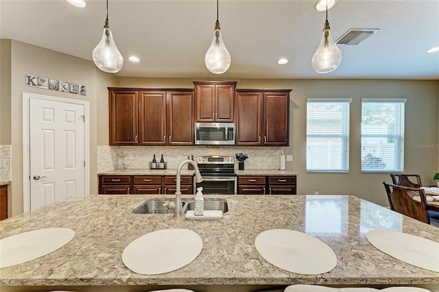 5307 65th Ter E, Ellenton, FL 34222 - kitchen featuring stainless steel appliances, a sink, decorative light fixtures, light stone counters, and recessed lighting