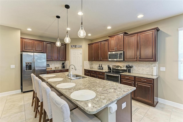 5307 65th Ter E, Ellenton, FL 34222 - kitchen with stainless steel appliances, a sink, baseboards, a kitchen bar, and recessed lighting
