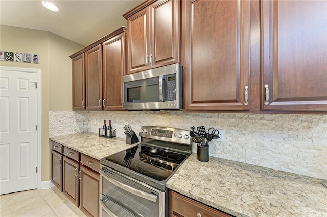5307 65th Ter E, Ellenton, FL 34222 - kitchen with appliances with stainless steel finishes, light stone counters, and tasteful backsplash