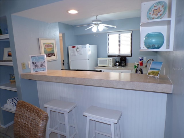 1801 Gulf Dr N Unit 207, Bradenton Beach, FL 34217 - kitchen with white appliances, a peninsula, and ceiling fan