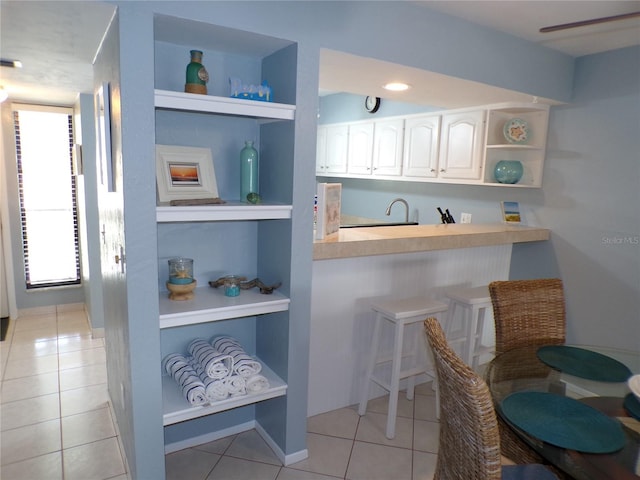 1801 Gulf Dr N Unit 207, Bradenton Beach, FL 34217 - kitchen with open shelves, light tile patterned flooring, white cabinets, light countertops, and built in features
