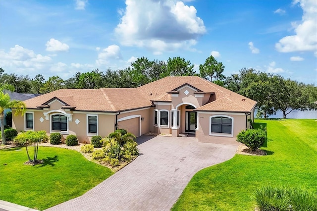 13503 22nd Ct E, Parrish, FL 34219 - mediterranean / spanish-style house featuring driveway, a garage, stucco siding, and a front yard
