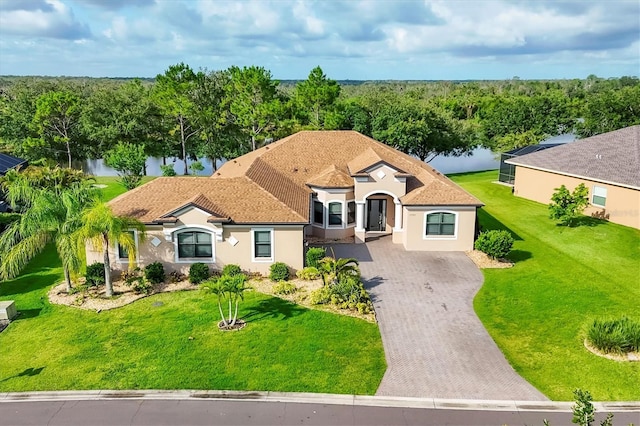 13503 22nd Ct E, Parrish, FL 34219 - view of front of house with decorative driveway, a water view, stucco siding, and a front yard