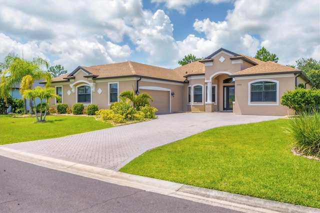 13503 22nd Ct E, Parrish, FL 34219 - mediterranean / spanish house featuring stucco siding, an attached garage, a front yard, and driveway