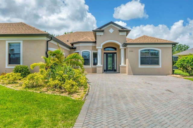 13503 22nd Ct E, Parrish, FL 34219 - mediterranean / spanish-style home with stucco siding, a front yard, and roof with shingles