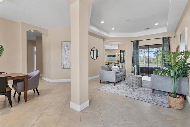 13503 22nd Ct E, Parrish, FL 34219 - living area featuring arched walkways, light tile patterned flooring, a tray ceiling, and recessed lighting