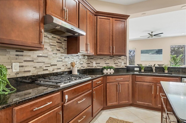 13503 22nd Ct E, Parrish, FL 34219 - kitchen featuring under cabinet range hood, ceiling fan, decorative backsplash, light tile patterned floors, and stainless steel gas cooktop