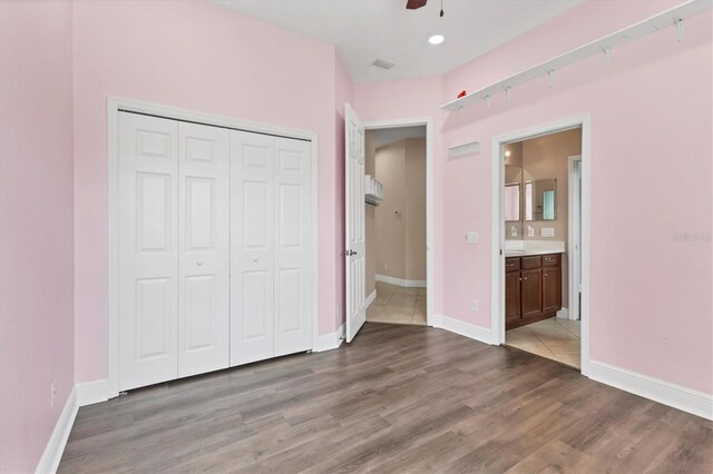 13503 22nd Ct E, Parrish, FL 34219 - unfurnished bedroom with wood finished floors, a closet, a ceiling fan, connected bathroom, and recessed lighting