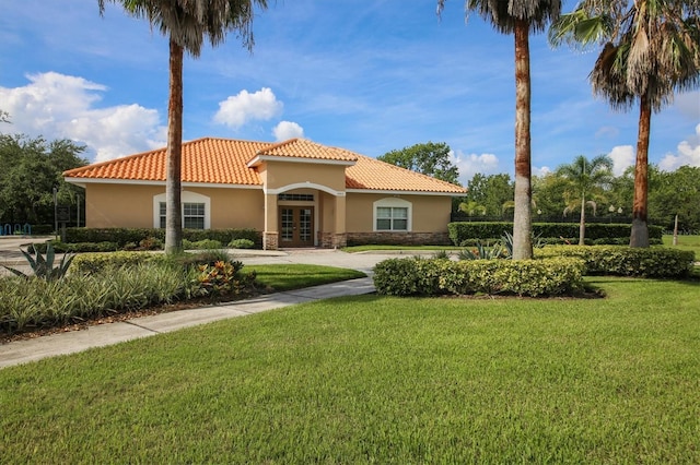 13503 22nd Ct E, Parrish, FL 34219 - mediterranean / spanish-style home with french doors, stucco siding, stone siding, a tile roof, and a front lawn