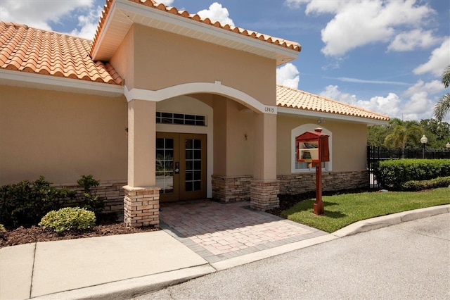 13503 22nd Ct E, Parrish, FL 34219 - property entrance featuring french doors, a tile roof, stucco siding, and stone siding