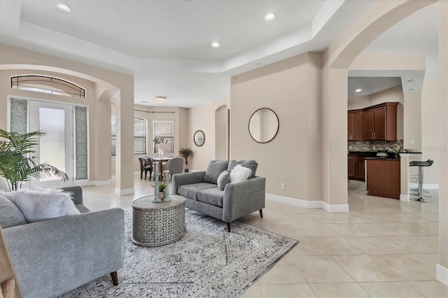 13503 22nd Ct E, Parrish, FL 34219 - living area featuring arched walkways, a tray ceiling, light tile patterned floors, and recessed lighting