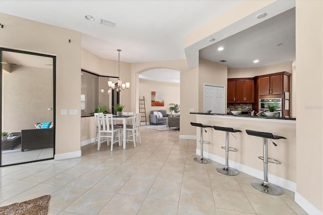 13503 22nd Ct E, Parrish, FL 34219 - kitchen with oven, dark countertops, a kitchen breakfast bar, tasteful backsplash, and arched walkways