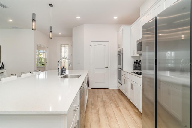 2108 Citrus Breeze Dr, Bradenton, FL 34208 - kitchen with appliances with stainless steel finishes, a large island, white cabinetry, light wood-style floors, and recessed lighting