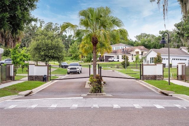 1841 Moorings Ct, Clermont, FL 34711 - view of asphalt road featuring sidewalks, curbs, and a gate