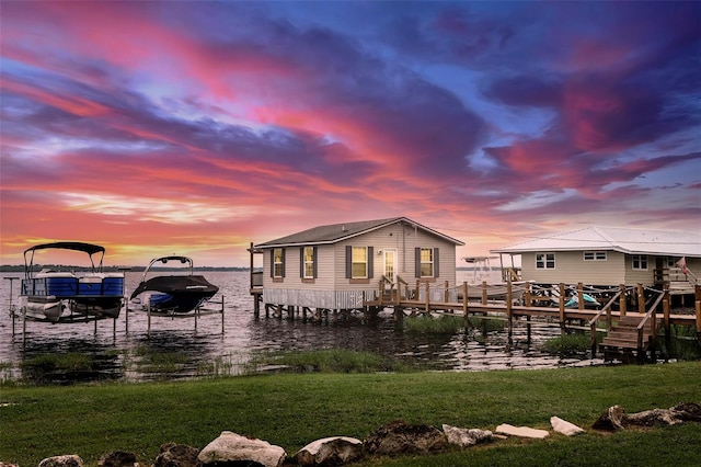 1841 Moorings Ct, Clermont, FL 34711 - back of property at dusk with boat lift, a water view, and a yard