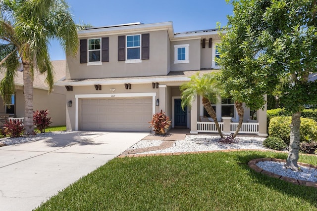 4617 Garden Arbor Way, Bradenton, FL 34203 - view of front of property with stucco siding, a porch, concrete driveway, and a garage