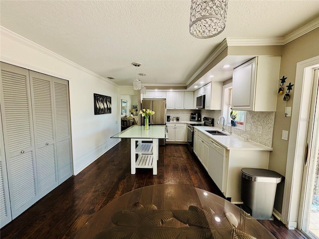 4907 Kilty Ct E, Bradenton, FL 34203 - kitchen featuring appliances with stainless steel finishes, dark wood-style flooring, light countertops, a textured ceiling, and crown molding